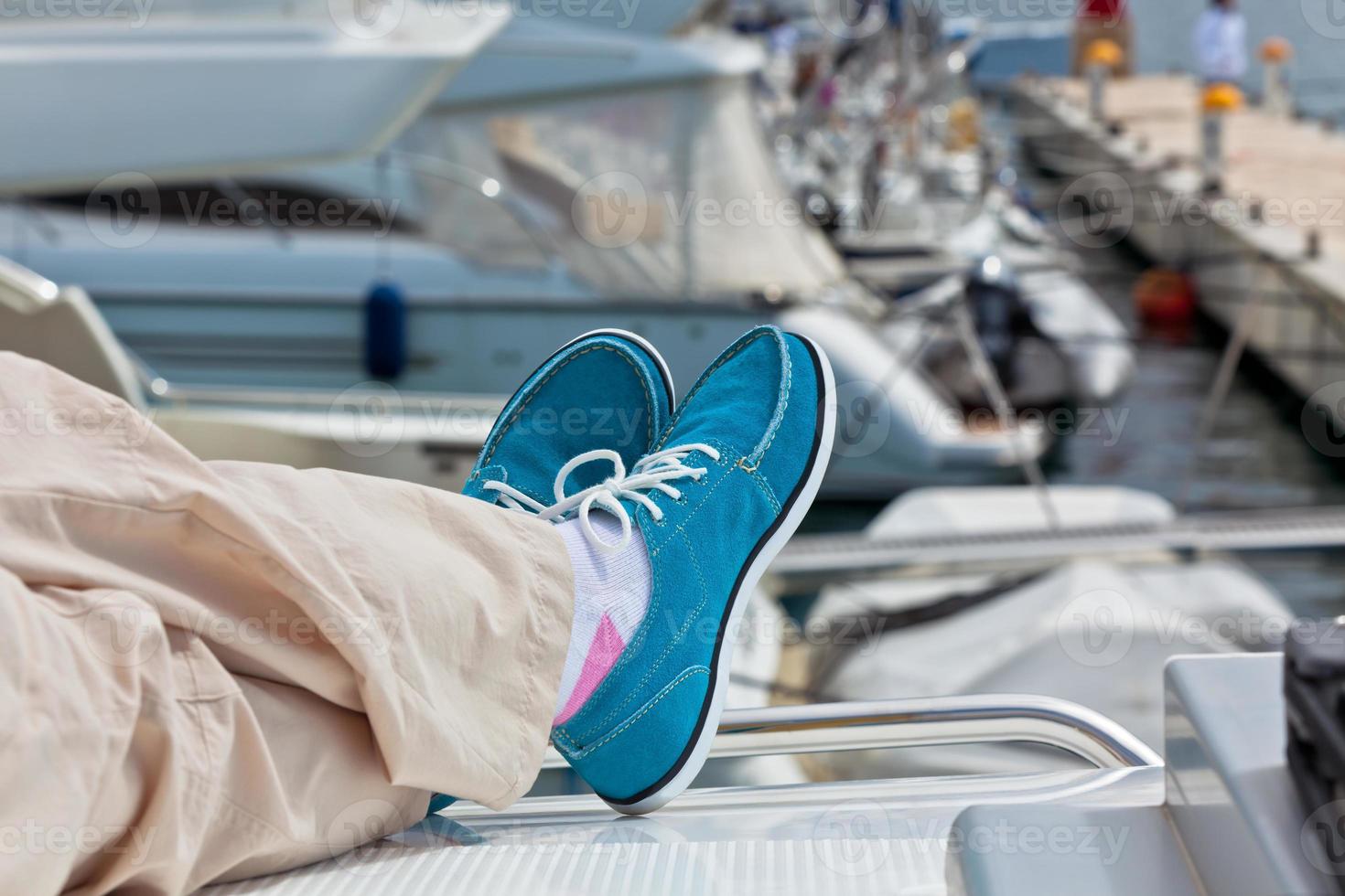 gambe nel pantaloni e luminosa blu topsider su yacht foto