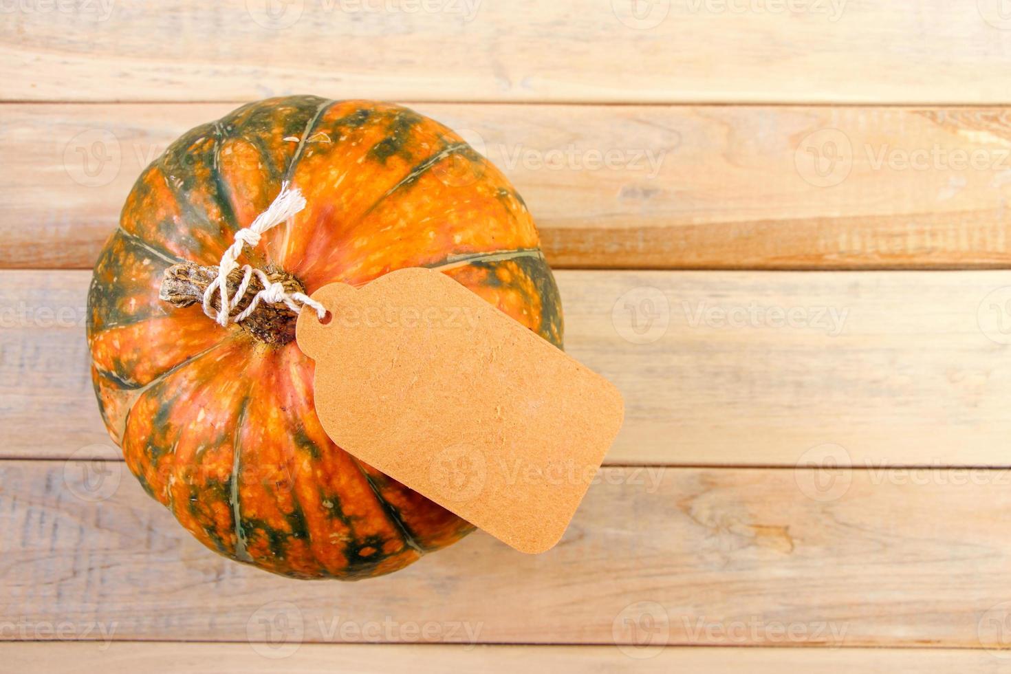 raccogliere e autunno vendita concetto. maturo zucca con etichetta su un' di legno sfondo. ringraziamento vacanza. copia spazio. foto