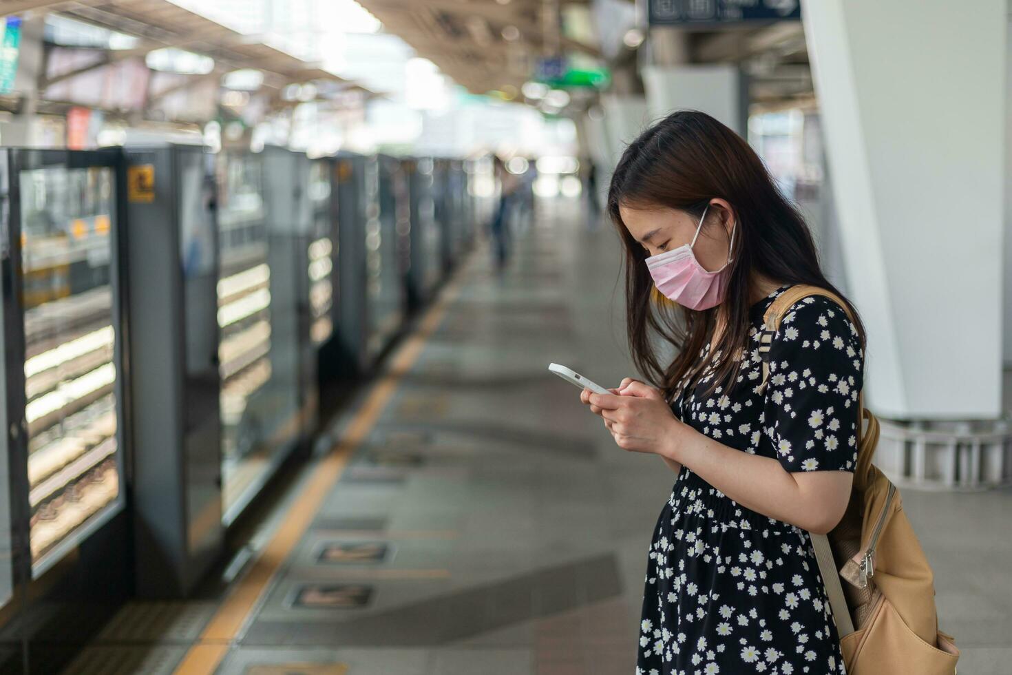 giovane asiatico donna passeggeri in attesa metropolitana treno quando in viaggio nel grande città foto