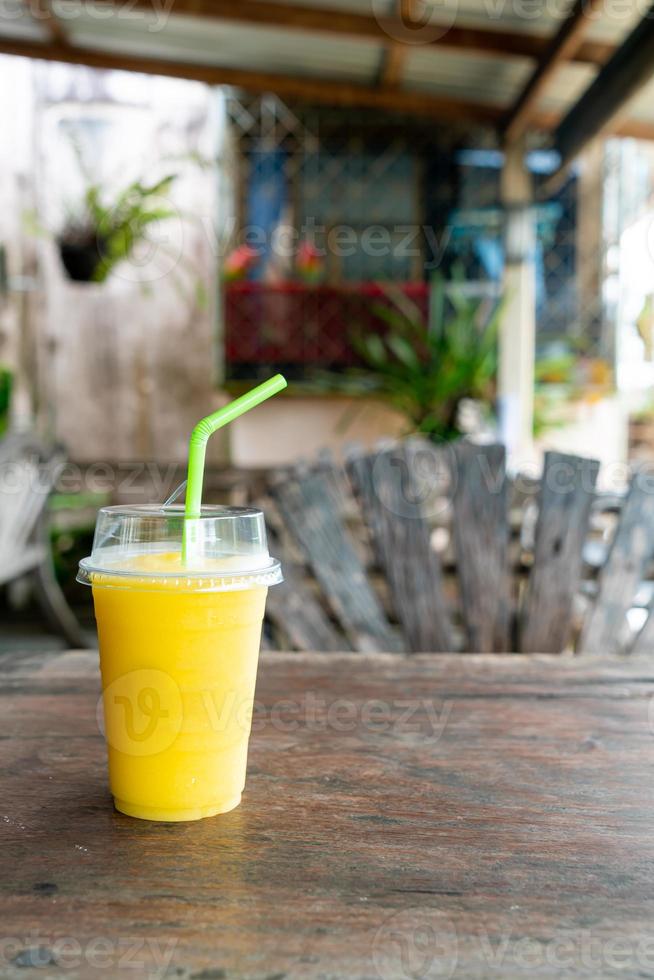 Mango frullati nel prendere lontano bicchiere foto