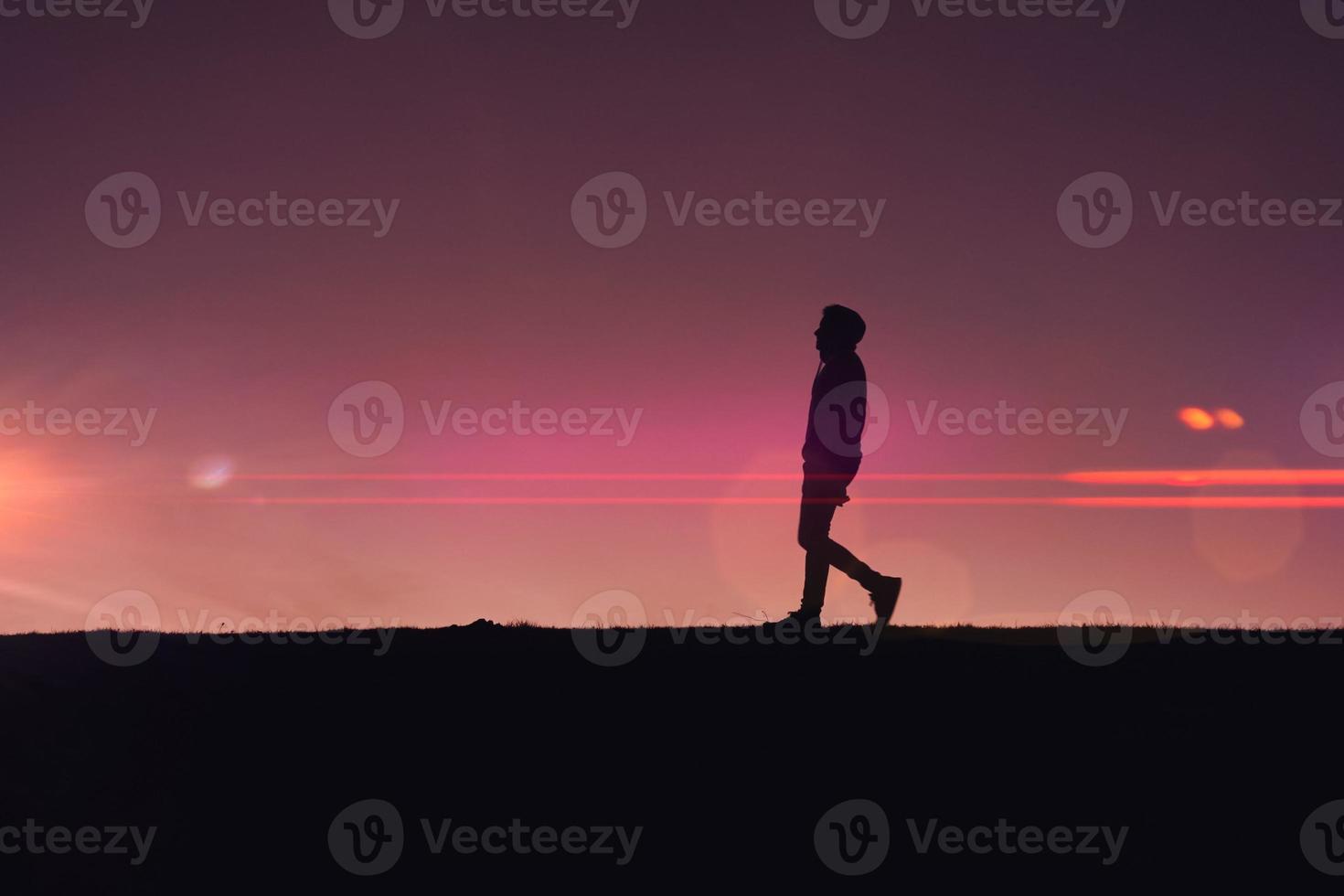 uomo il trekking nel il campagna con un' bellissimo tramonto sfondo foto