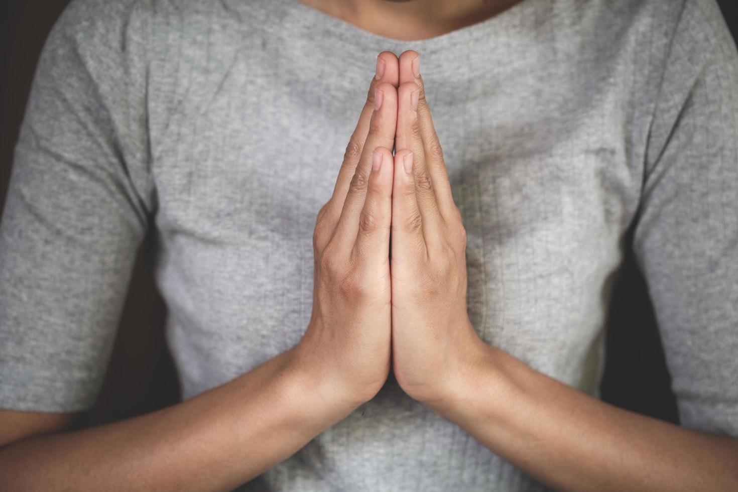 namaste o namaskar mani gesto, preghiera posizione, preghiere mani con fede nel religione e credenza nel Dio su buio sfondo. energia di speranza o amore e devozione. foto