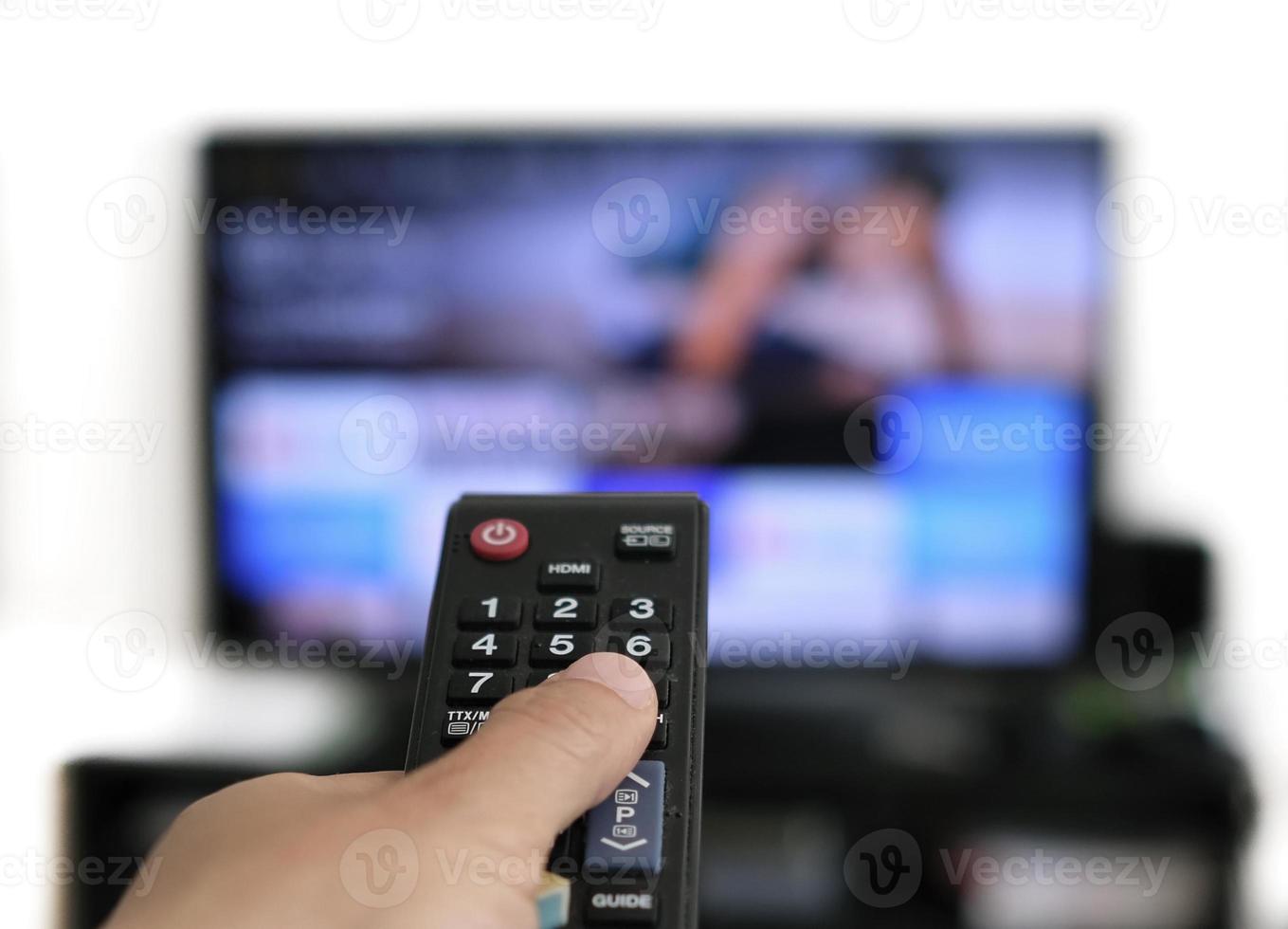 telecomando e schermo - abbuffarsi di guardare il programma televisivo preferito foto