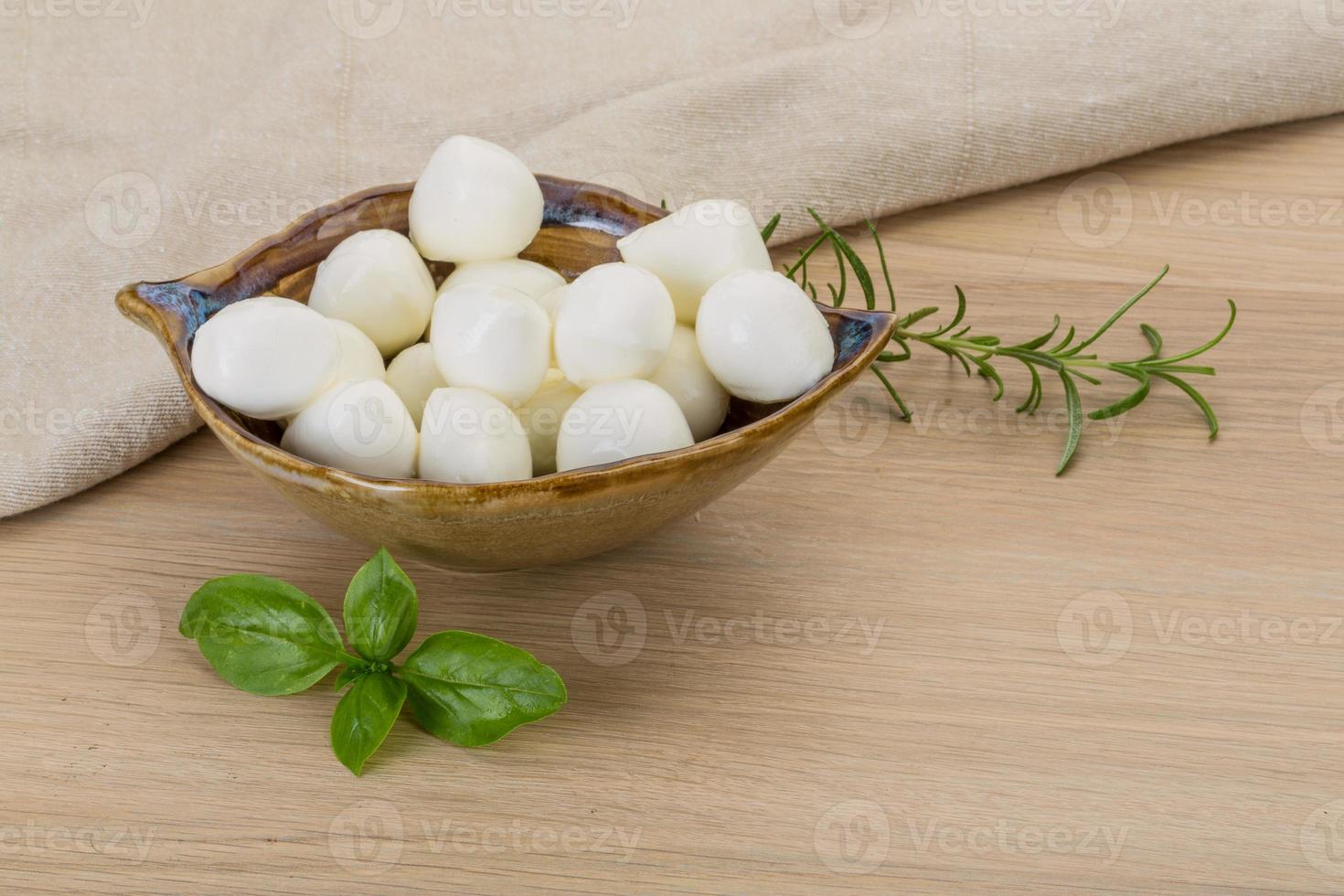 Mozzarella formaggio nel un' ciotola su di legno sfondo foto