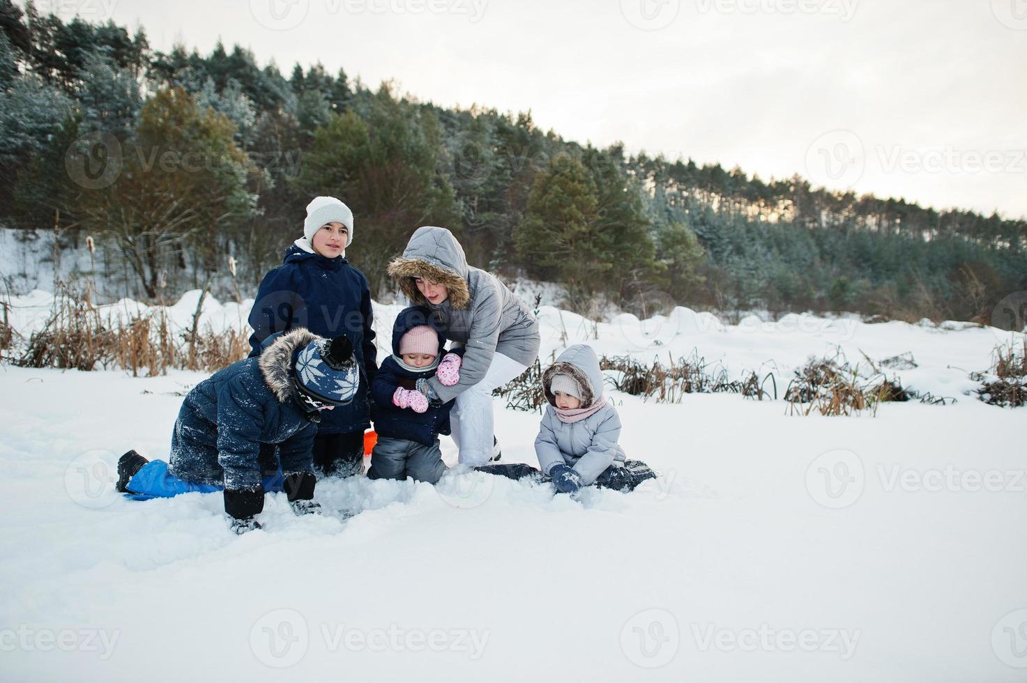 madre con quattro figli nella natura invernale. all'aperto nella neve. foto