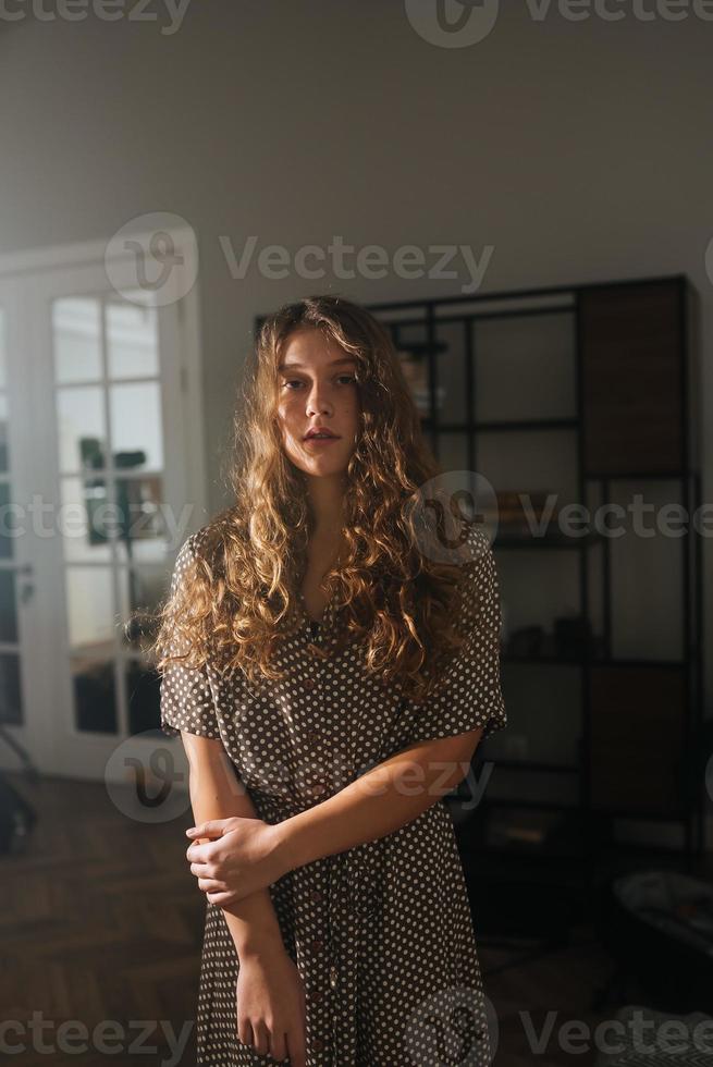 grave bellissimo giovane donna nel vestito in posa per il telecamera. foto