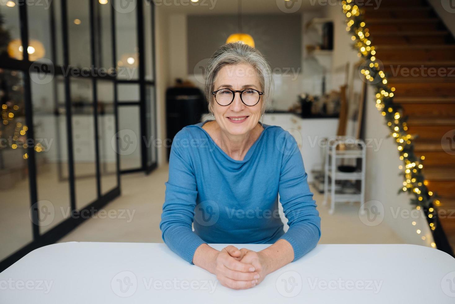 ritratto anziano donna indossare bicchieri guardare e sorridente a telecamera foto