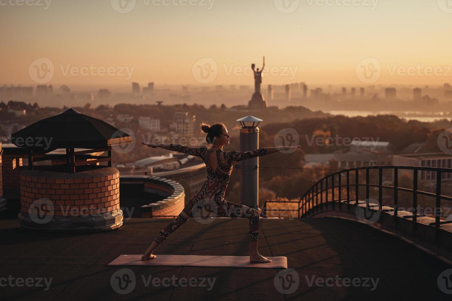 donna fare yoga su il tetto di un' grattacielo nel grande città. foto