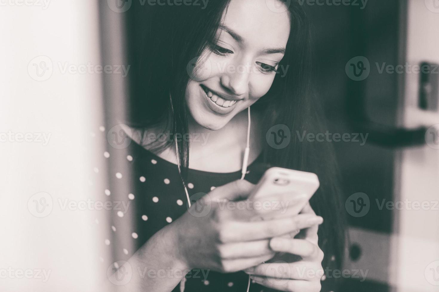 bella ragazza che ascolta la musica al telefono con le cuffie foto