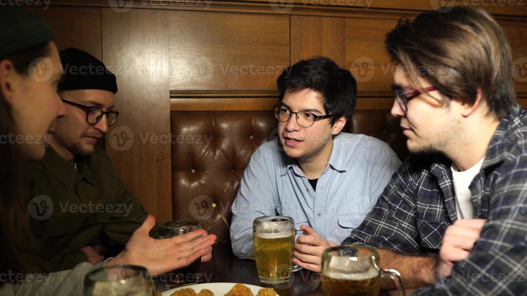 giovane amici avendo divertimento insieme potabile birra nel un' pub. foto