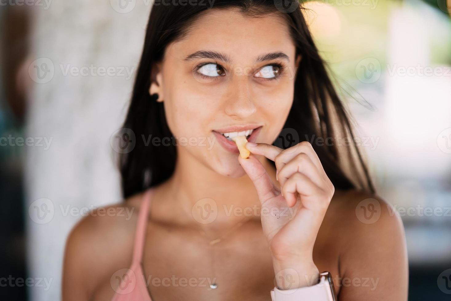 giovane donna mangiare francese patatine fritte, avendo sua pranzo rompere. foto