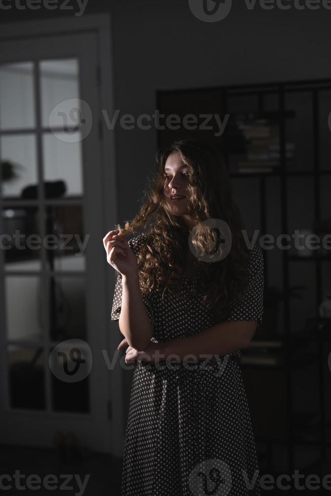 grave bellissimo giovane donna nel vestito in posa per il telecamera. foto