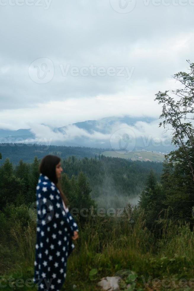 donna in piedi su superiore di un' collina, contro il sfondo di un' valle foto