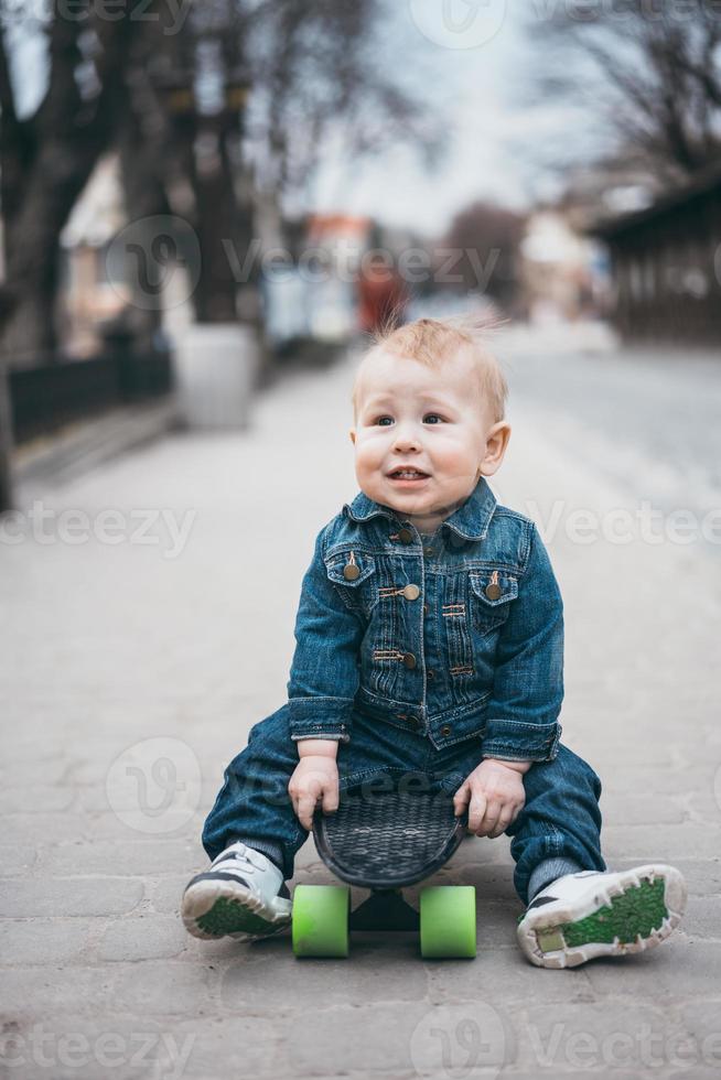 poco divertente ragazzo con skateboard su il strada foto