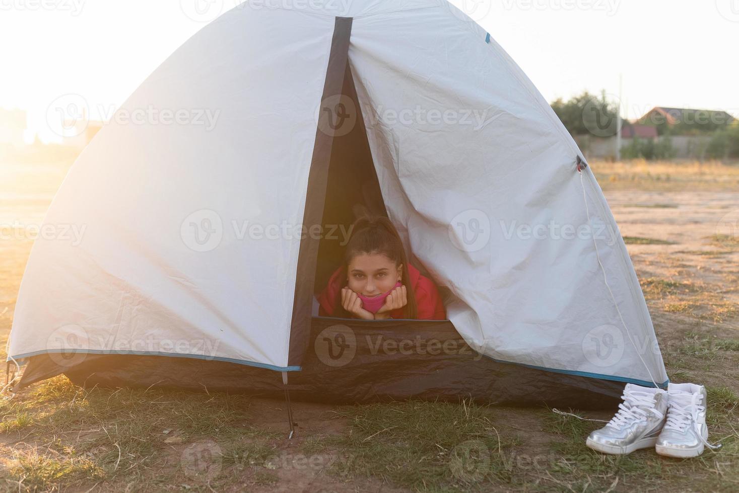 giovane donna sbirciando su di il tenda con solo sua testa attaccare su foto