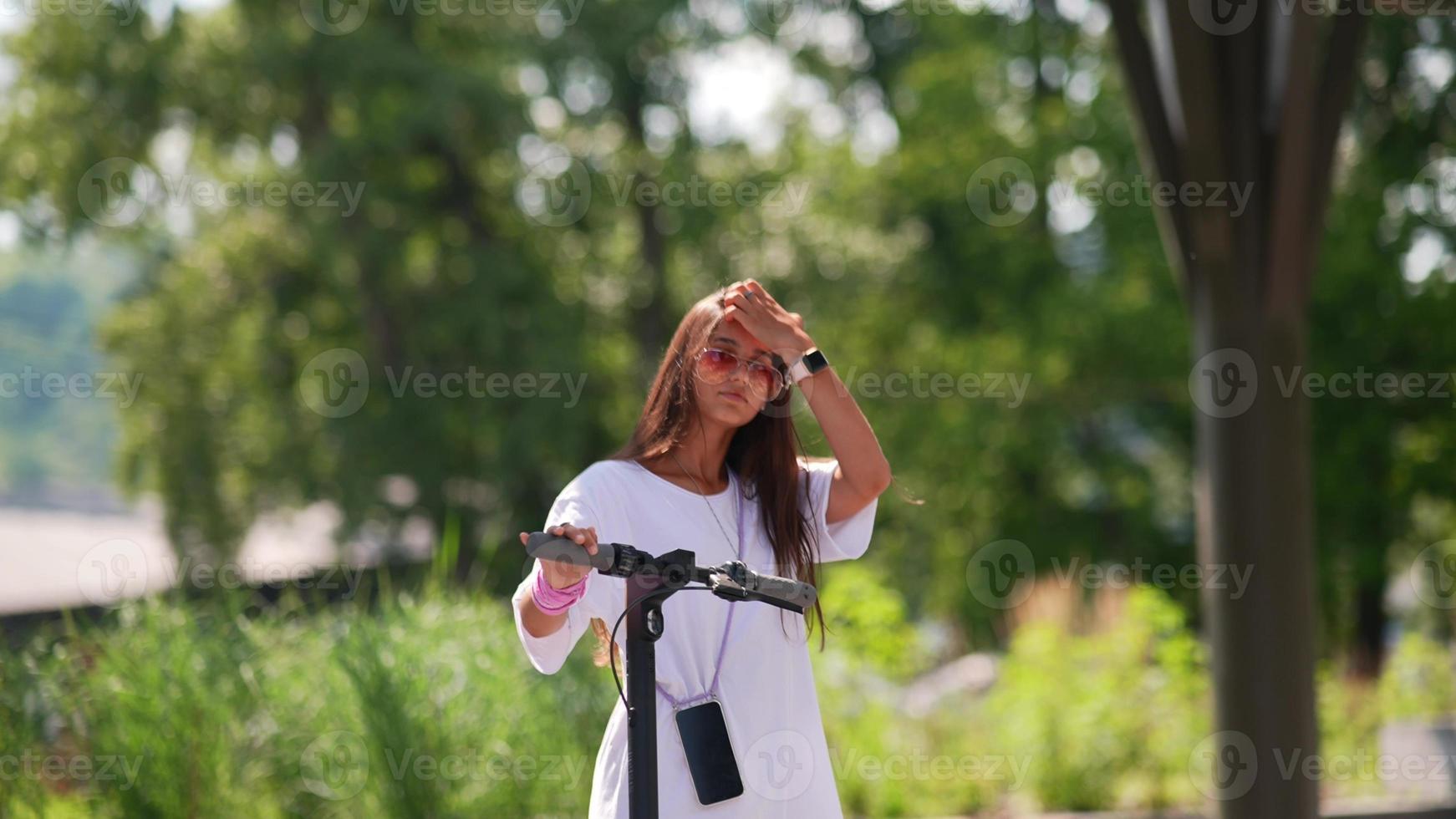 giovane bellissimo donna e elettrico scooter nel il parco foto