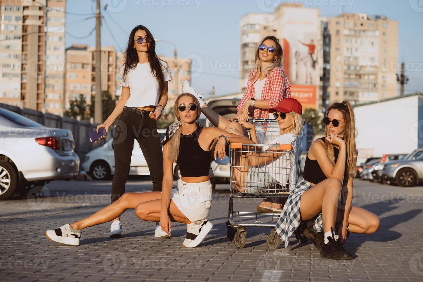 giovane donne con un' supermercato carrello avere divertimento foto