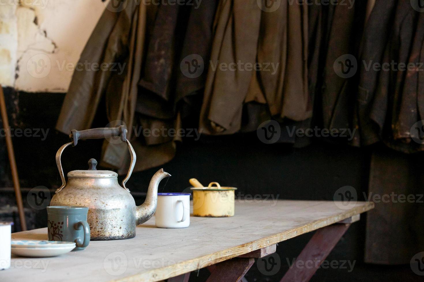 vecchia mensa degli operai con tuta e bollitore sul tavolo di legno foto
