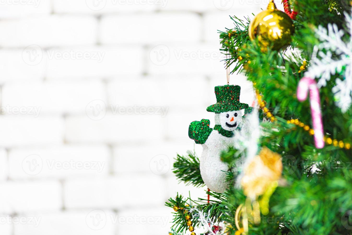 Natale e nuovo anno vacanza concetto. avvicinamento e sfocatura Natale albero decorazione con nastri palle e ornamenti al di sopra di bianca mattone parete e bokeh foto