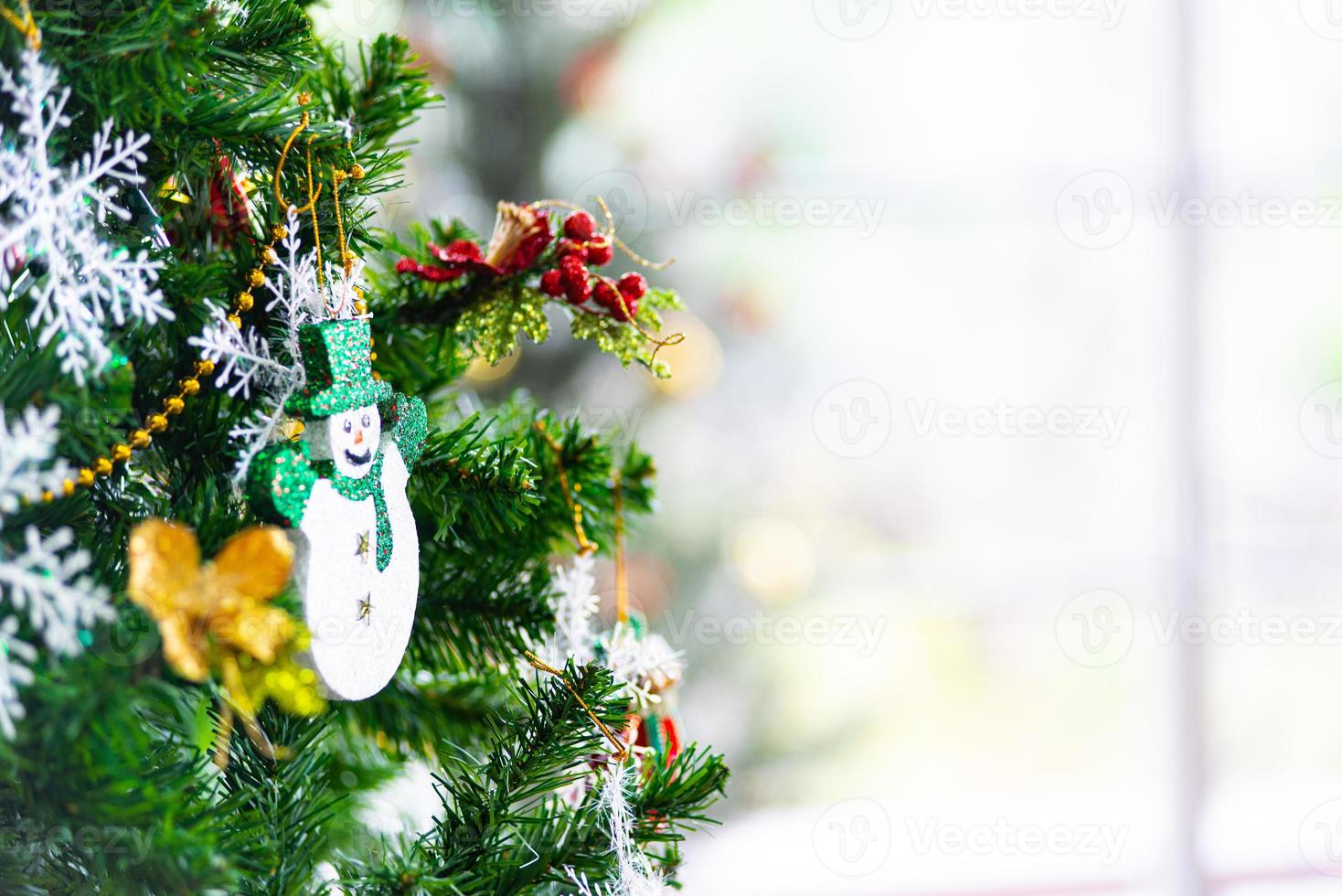 Natale e nuovo anno vacanza concetto. avvicinamento e sfocatura Natale albero decorazione con nastri palle e ornamenti al di sopra di bianca mattone parete e bokeh foto