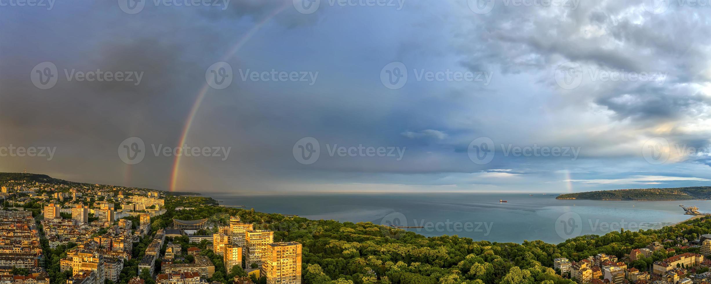 sbalorditivo panorama di un' grande arcobaleno al di sopra di il mare e costa dopo il pioggia foto