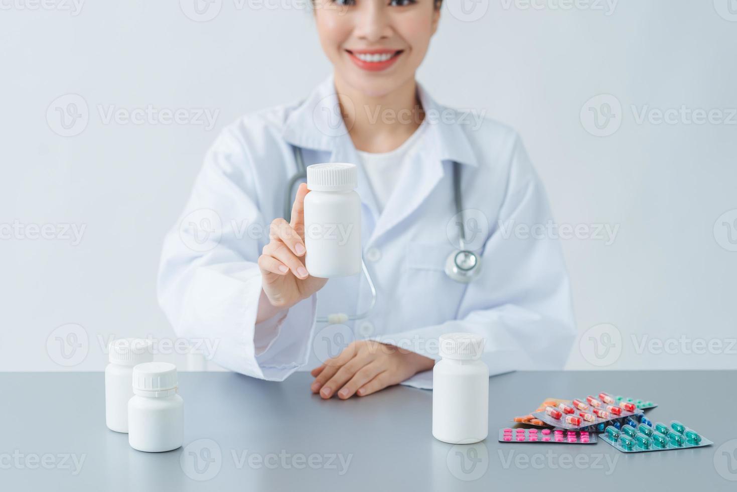 bellissimo femmina medico medicina medico o farmacista seduta a tavolo da lavoro foto