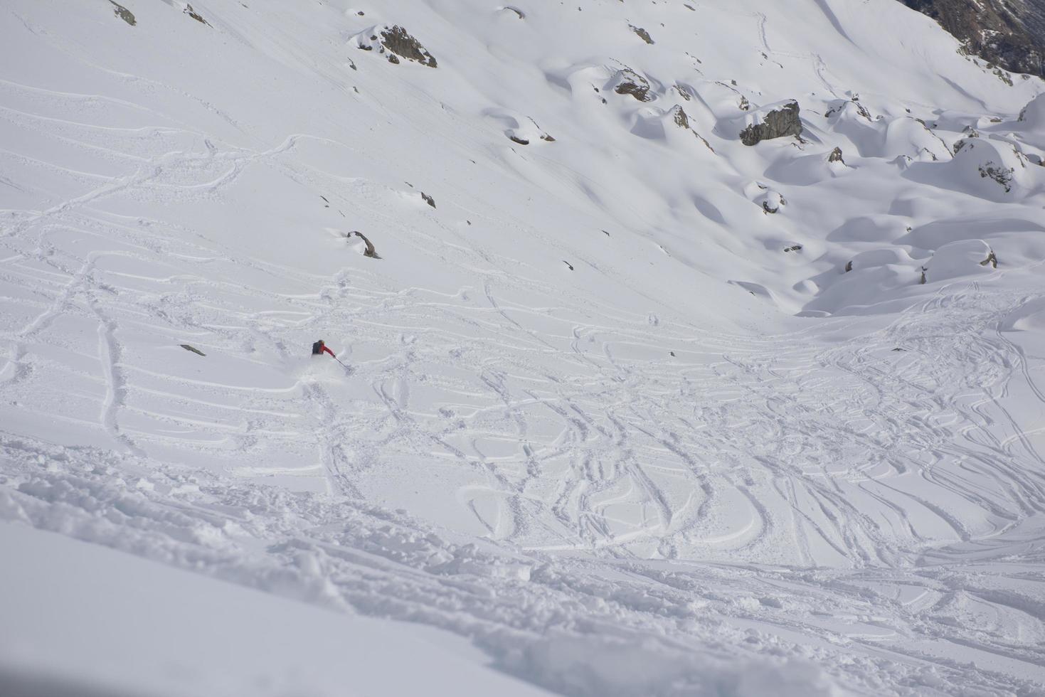 sciatore freeride che scia nella neve farinosa profonda foto