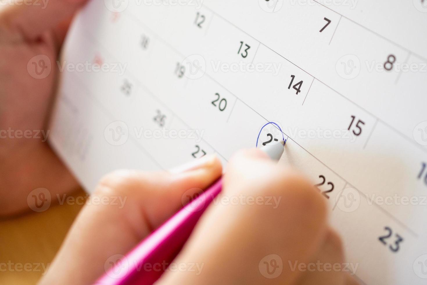 pagina del calendario con penna a mano femminile foto