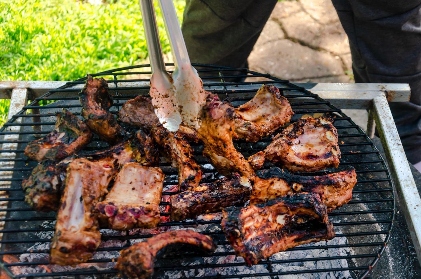 scorta costolette cucinando su griglia, all'aperto Manzo e Maiale bbq foto