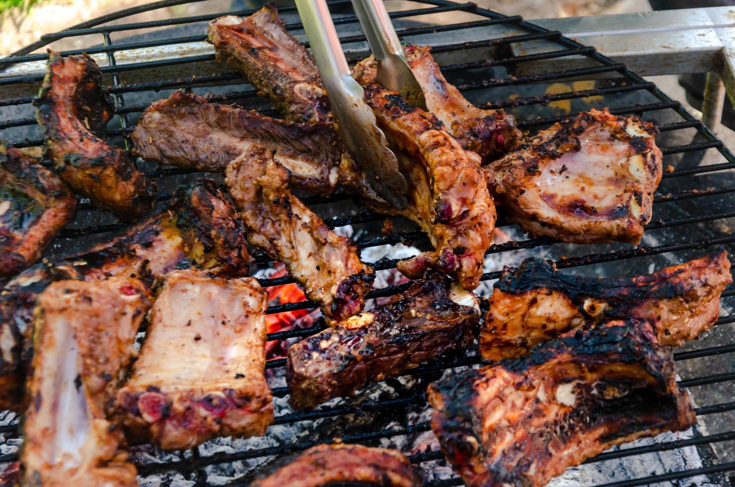 scorta costolette cucinando su griglia, all'aperto Manzo e Maiale bbq foto