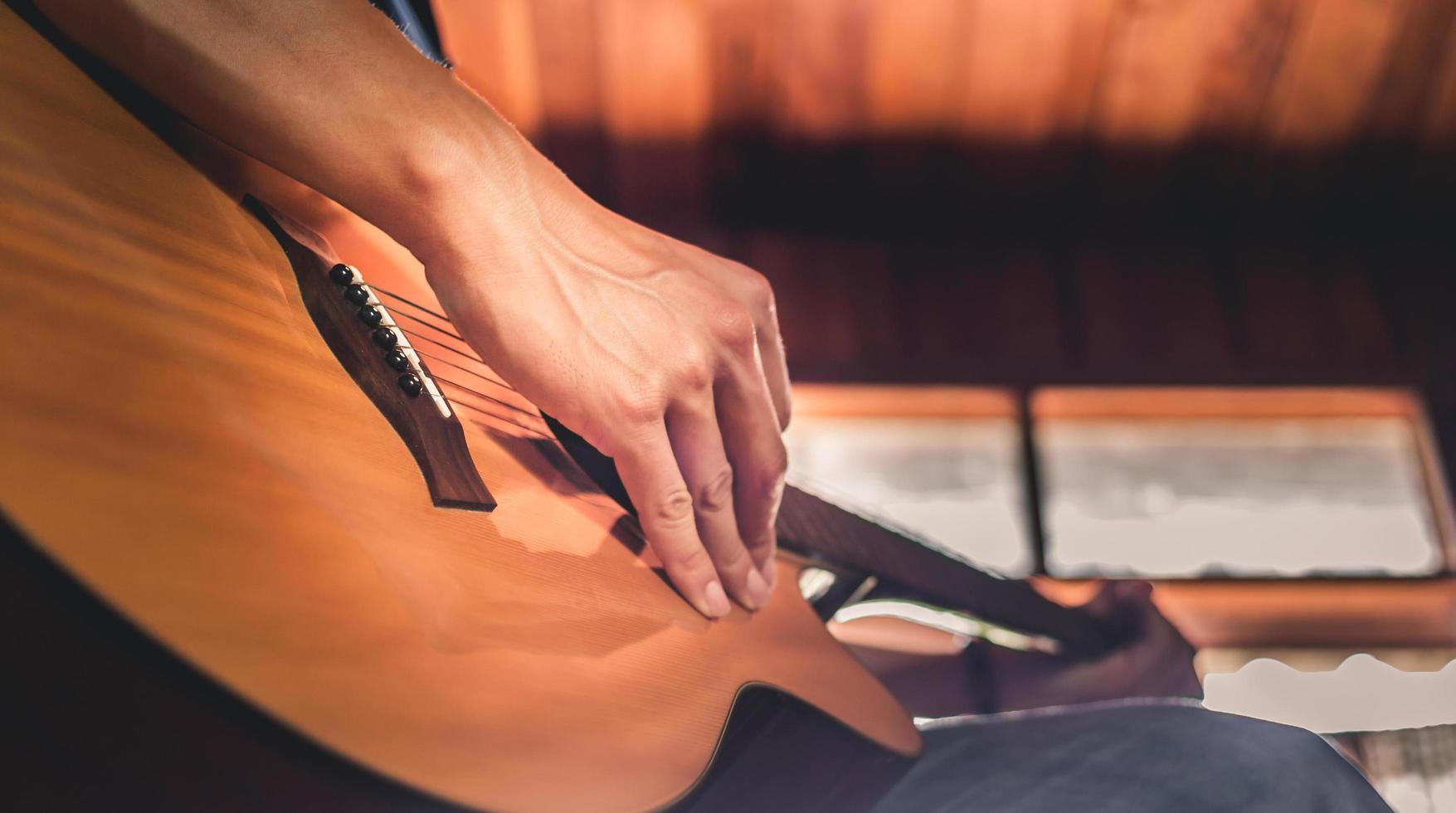 avvicinamento di il mani e dita di un' maschio musicista giocando un acustico chitarra.musicale chitarra strumento per ricreazione o rilassare passatempo passione concetto. foto