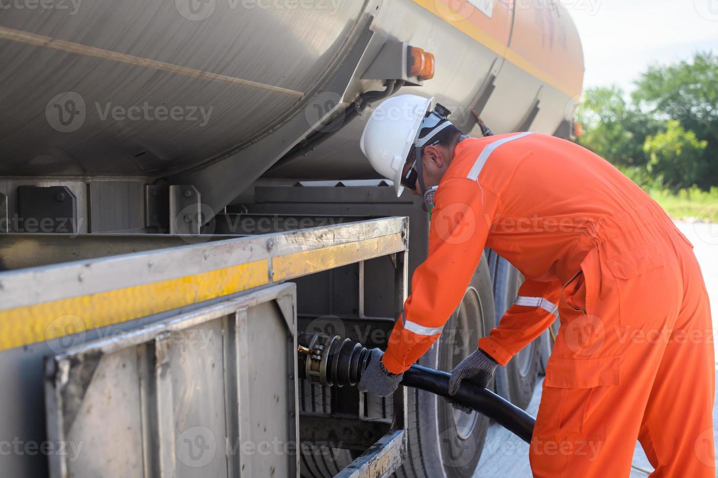 un' uomo lavori nel un olio campo e è utilizzando olio tubi per Fare rifornimento. foto
