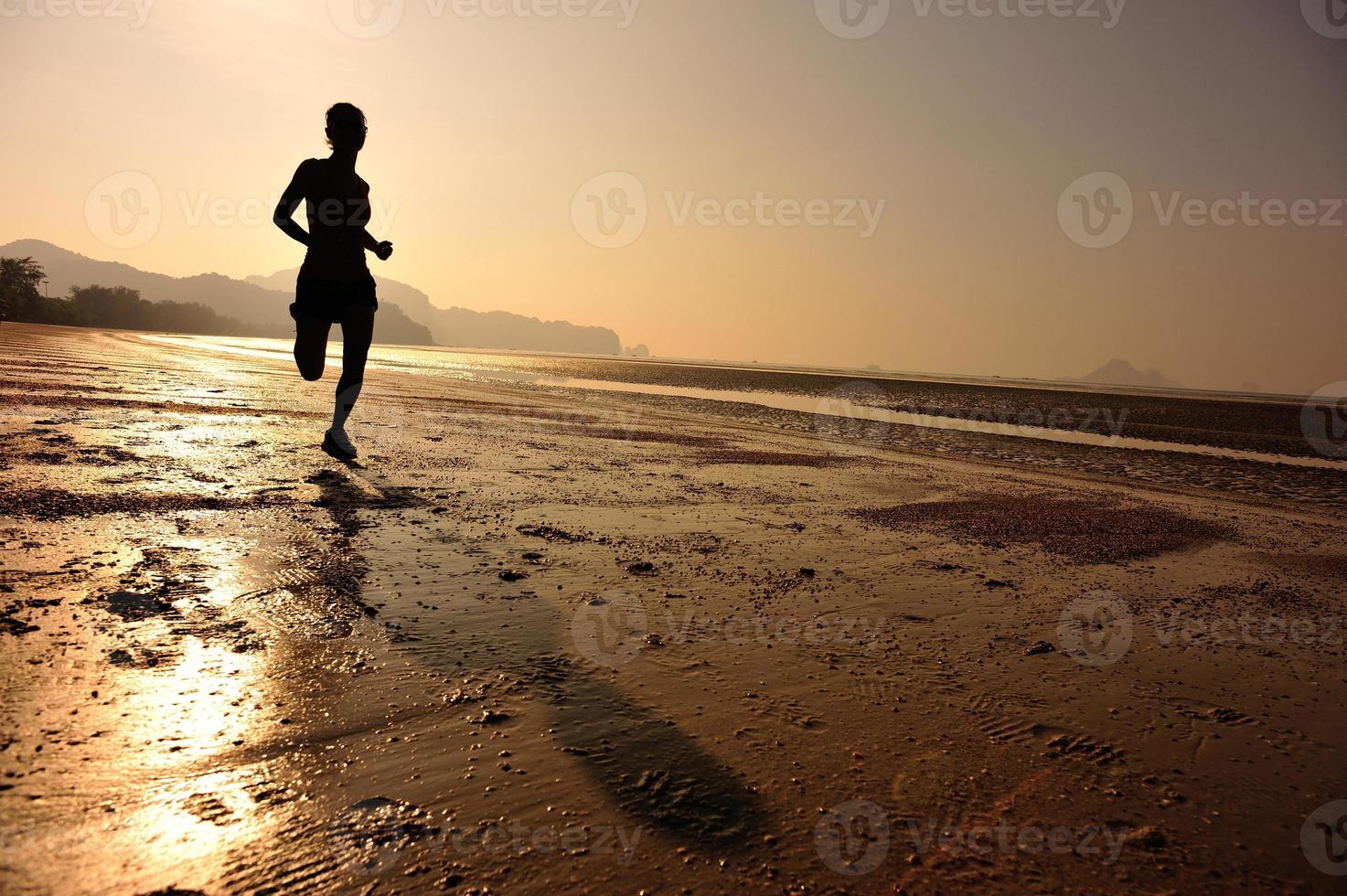 giovane donna fitness in esecuzione sulla spiaggia di alba foto