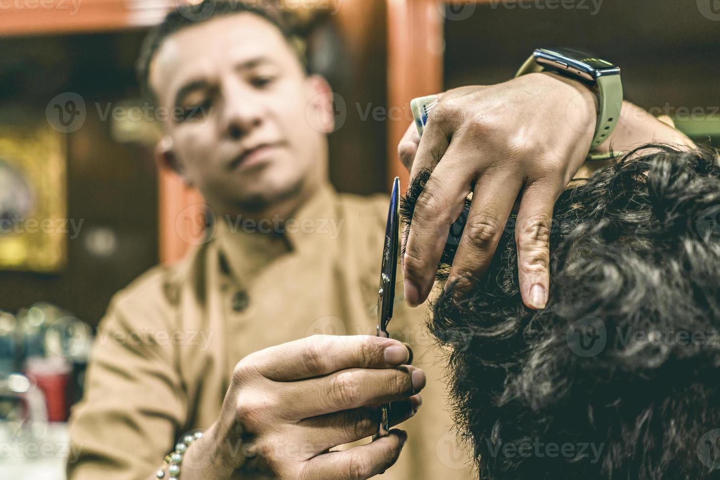 avvicinamento di un' del barbiere mani taglio un' dell'uomo capelli. foto