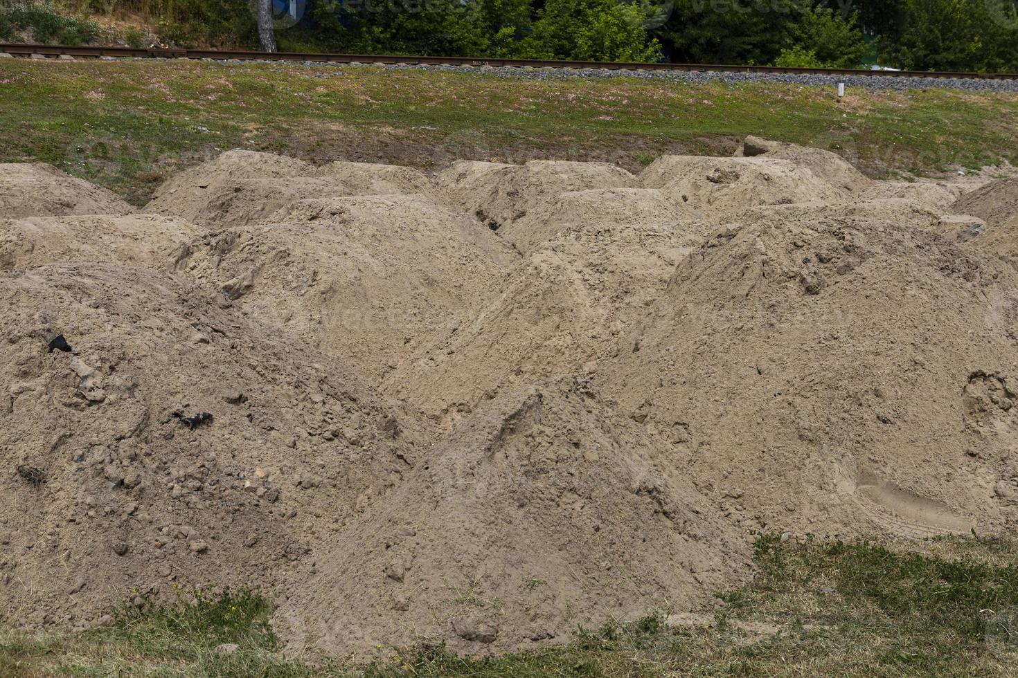 costruzione sabbia. montagna di sabbia su costruzione luogo. scavato terra. preparazione di fondazione per strada. foto