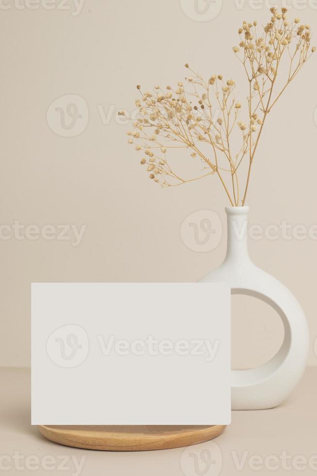 saluto carta davanti Visualizza e asciutto fiore nel vaso ceramica su tavolo foto