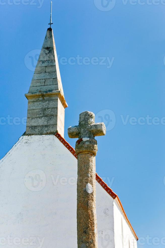 vecchio pietra attraversare e tetto di nazione cappella con blu cielo sfondo foto