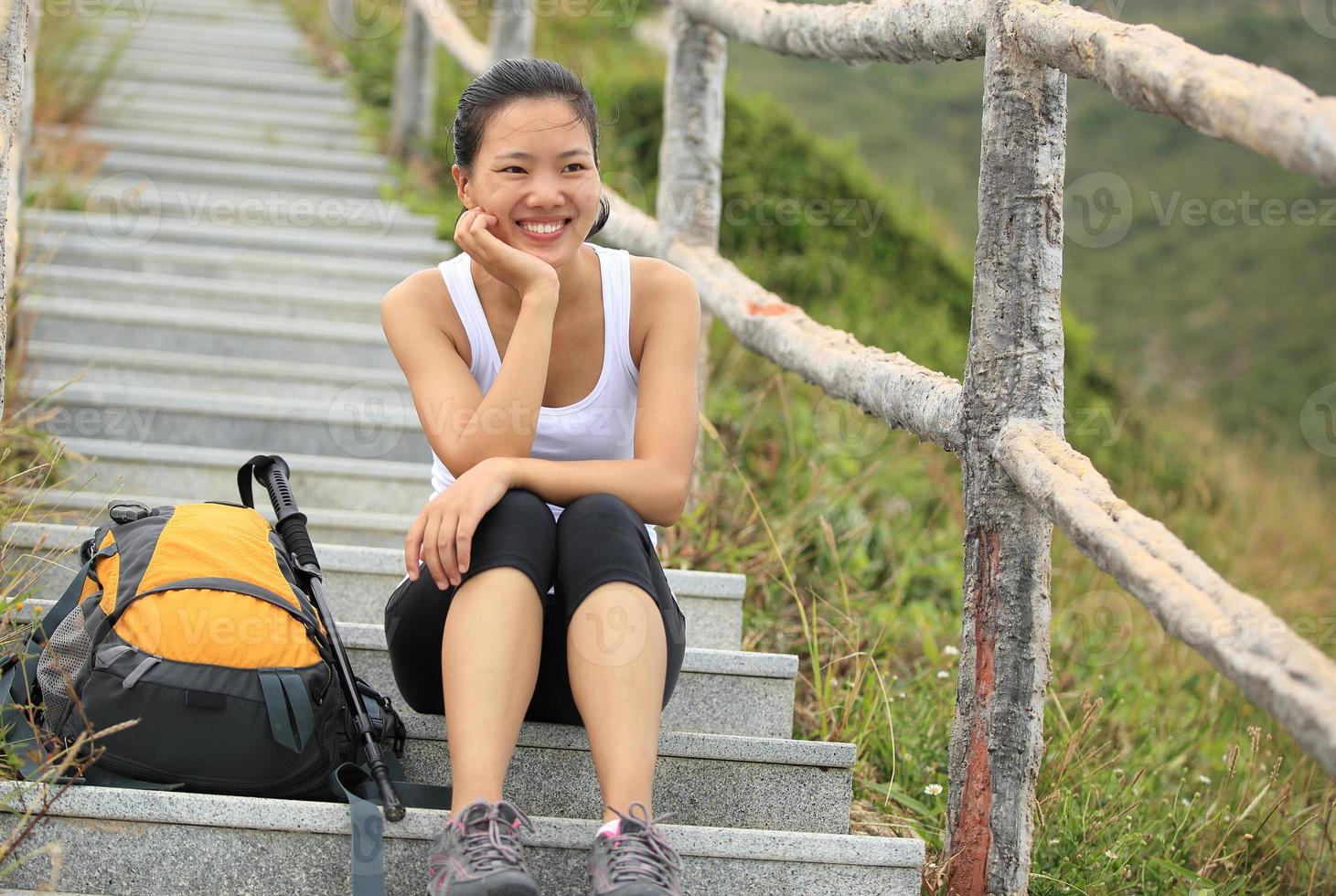 la giovane viandante asiatica della donna si siede le scale della montagna foto