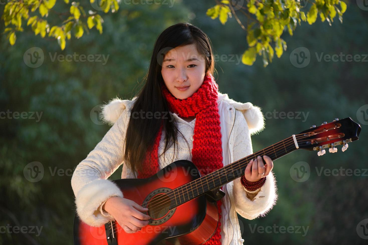 ragazza asiatica a suonare la chitarra foto