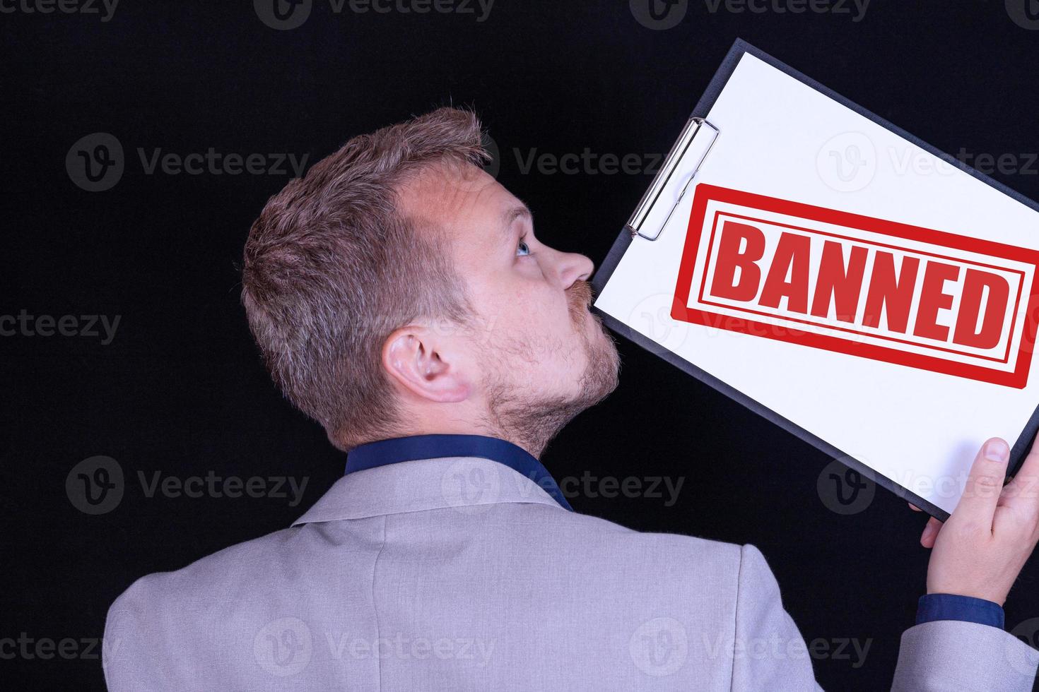 un' uomo d'affari detiene un' vuoto foglio di carta con il testo vietato. attività commerciale concetto. foto