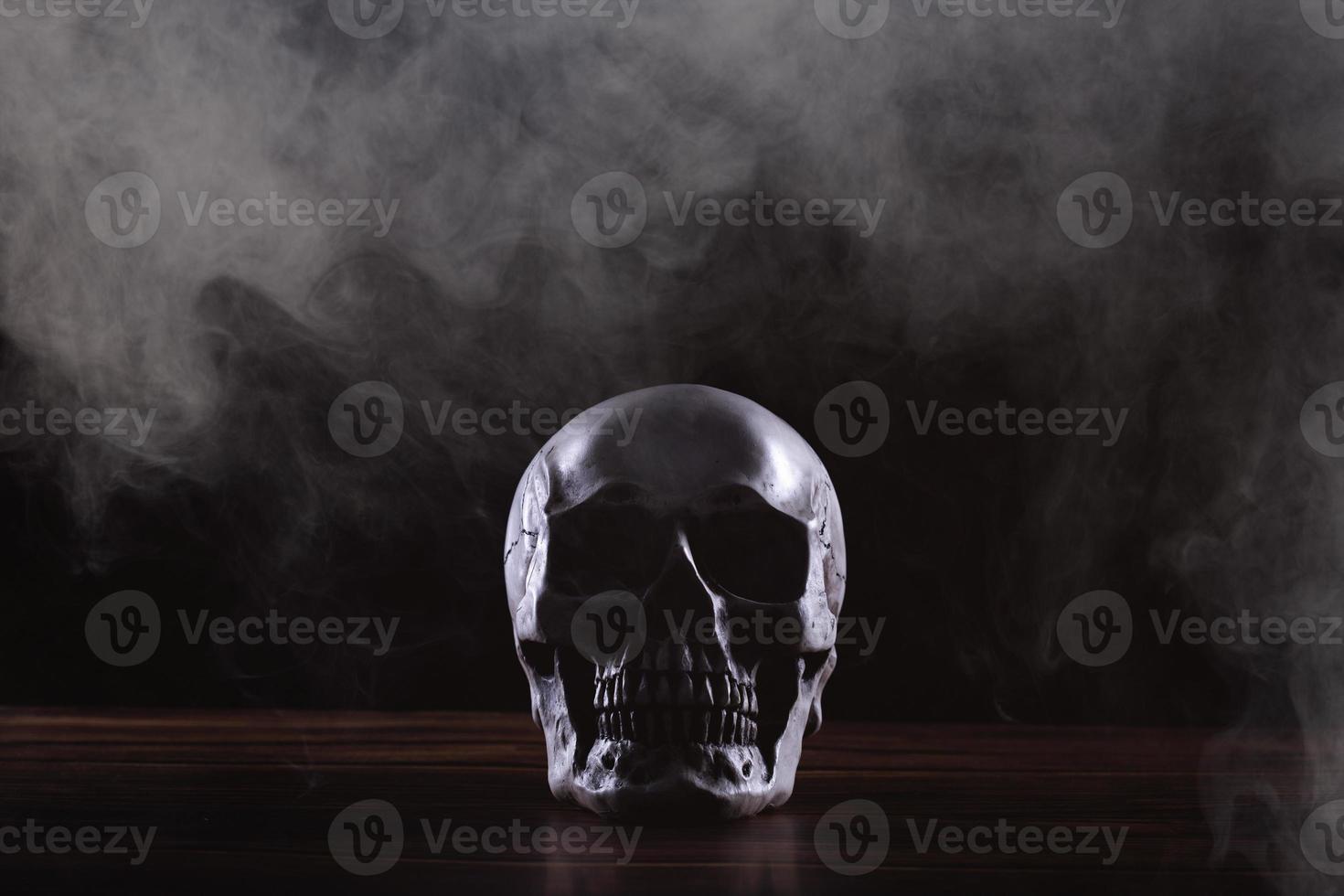 Halloween umano cranio su un vecchio di legno tavolo al di sopra di nero sfondo. forma di cranio osso per Morte testa su Halloween Festival quale mostrare orrore il male dente paura e pauroso con nebbia Fumo, copia spazio foto