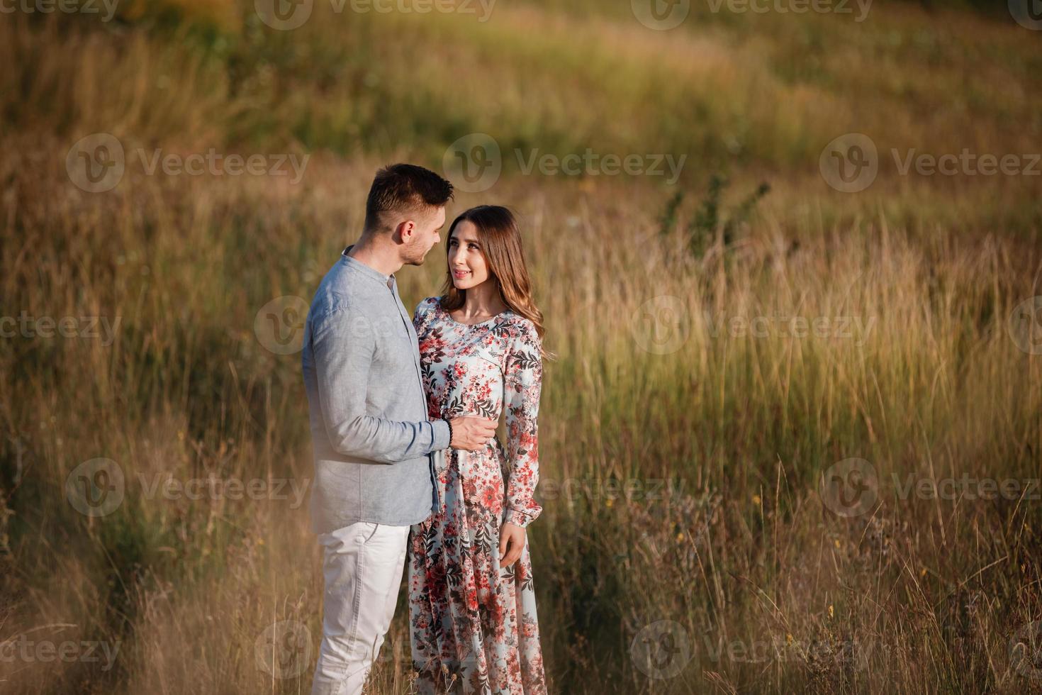 giovane coppia che riposa in natura in un campo. coppia al tramonto foto