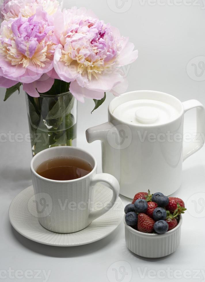 tazza di tè, peonia e frutti di bosco. foto