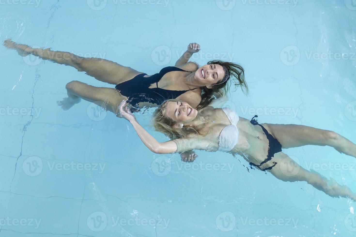 bellissimo contento donne con sexy in forma corpo rilassante, galleggiante nel nuoto piscina a terme Hotel. estate vacanze vacanza. salutare stile di vita. benessere, bellezza, Salute concetto. ricreazione foto