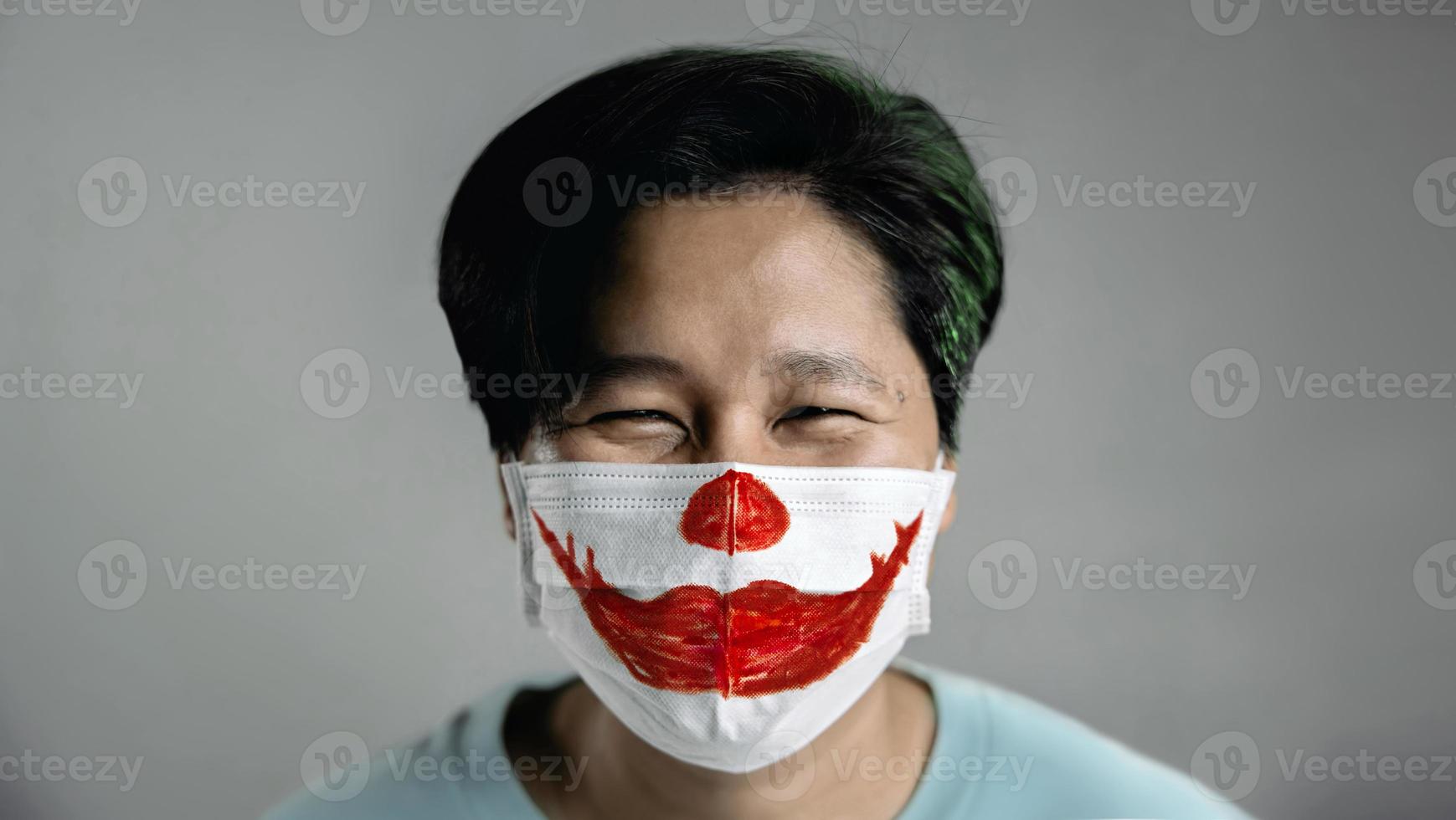 Halloween nel covid-19 situazione concetto. contento persona indossare un' chirurgico maschera. rosso sorridente rossetto dipinto su maschera foto