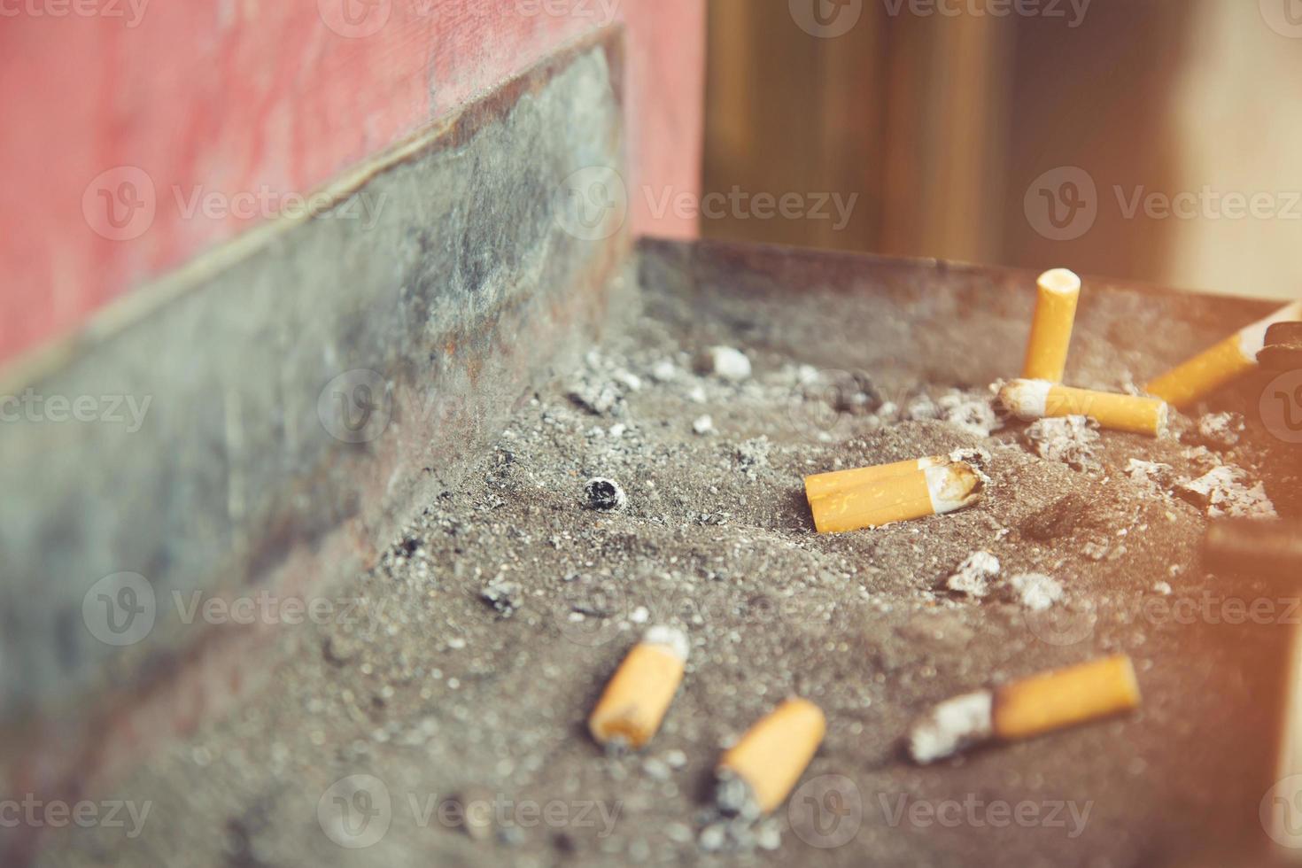 fumo un' sigaretta polverizzare su il portacenere mozziconi pubblico , smettere fumare. Salute concetto. foto