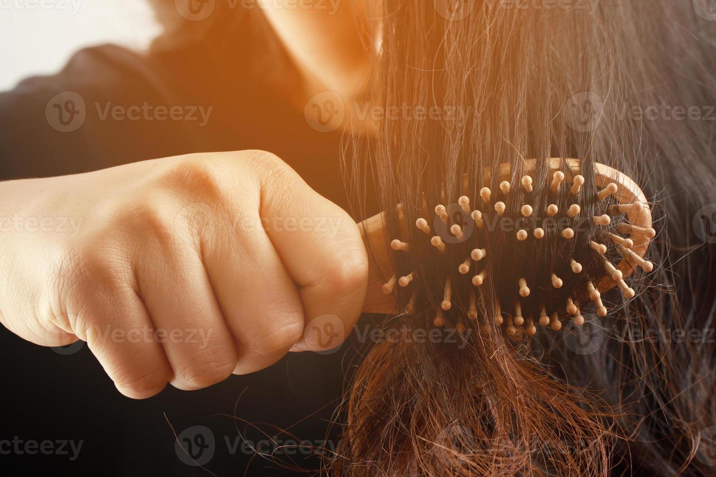 posteriore Visualizza giovane donna preoccupato di capelli perdita problema, ormonale squilibrio, fatica concetto. molti capelli autunno dopo pettinatura nel capelli spazzola nel mano. femmina districato sua capelli con un' pettine, Salute cura foto