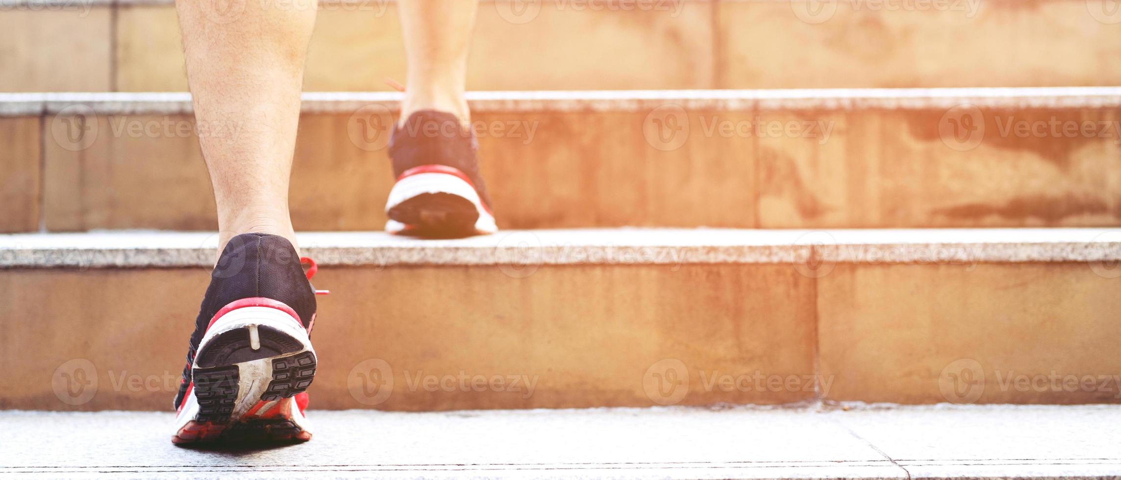 uomo Lavorando avvicinamento gambe a piedi su il le scale nel moderno città. nel corsa ora per opera nel ufficio un' fretta. durante il primo mattina di opera. scala. morbido messa a fuoco. foto