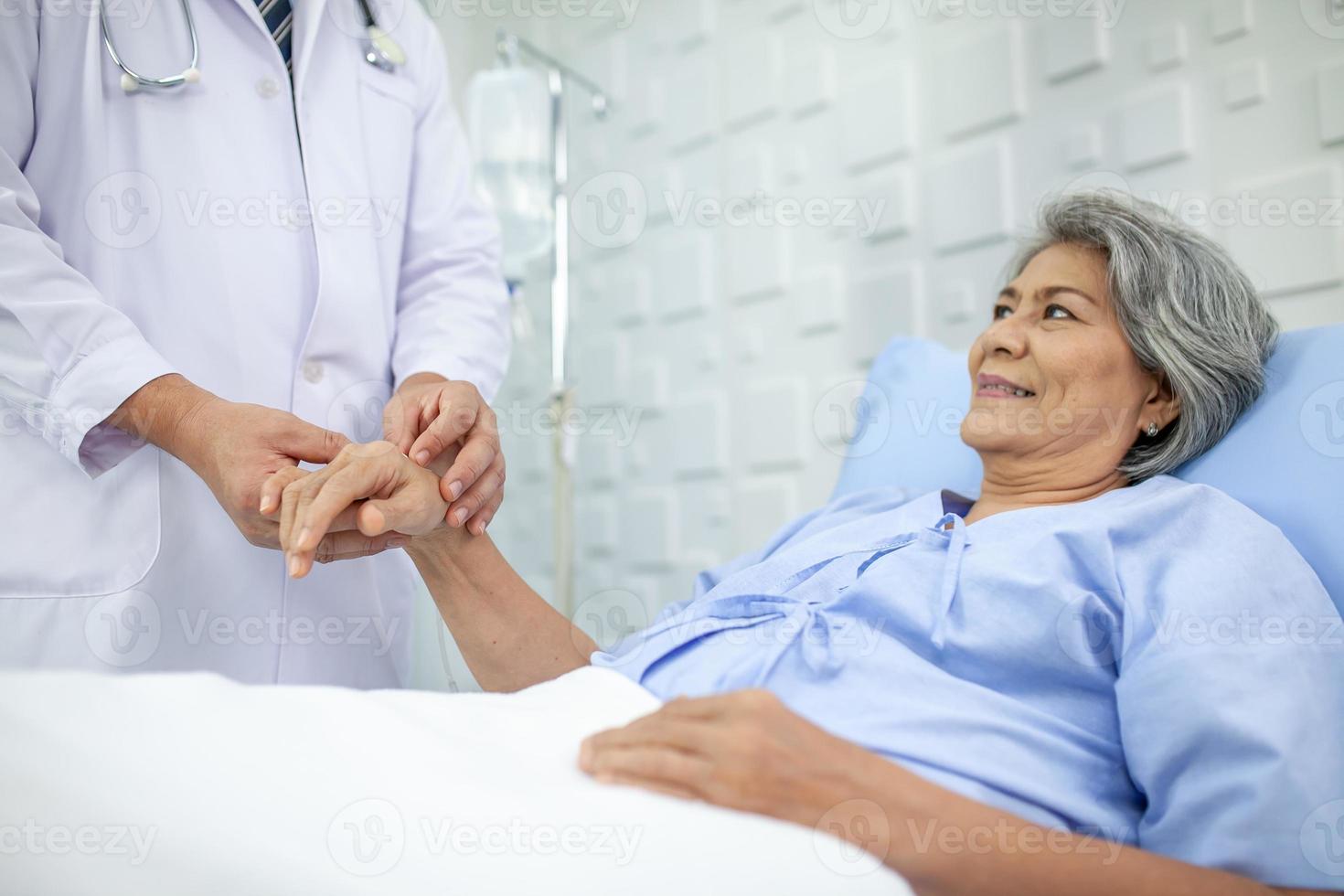 asiatico medico supporto e applauso su anziano paziente nel Ospedale, parlando sorridente nel comfort. assistenza sanitaria e medicina concetto. foto