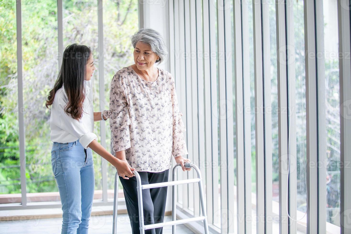 asiatico ragazza assistere anziano donna provando per camminare a casa, Salute cura, anziano terapia paziente a casa concetto. foto